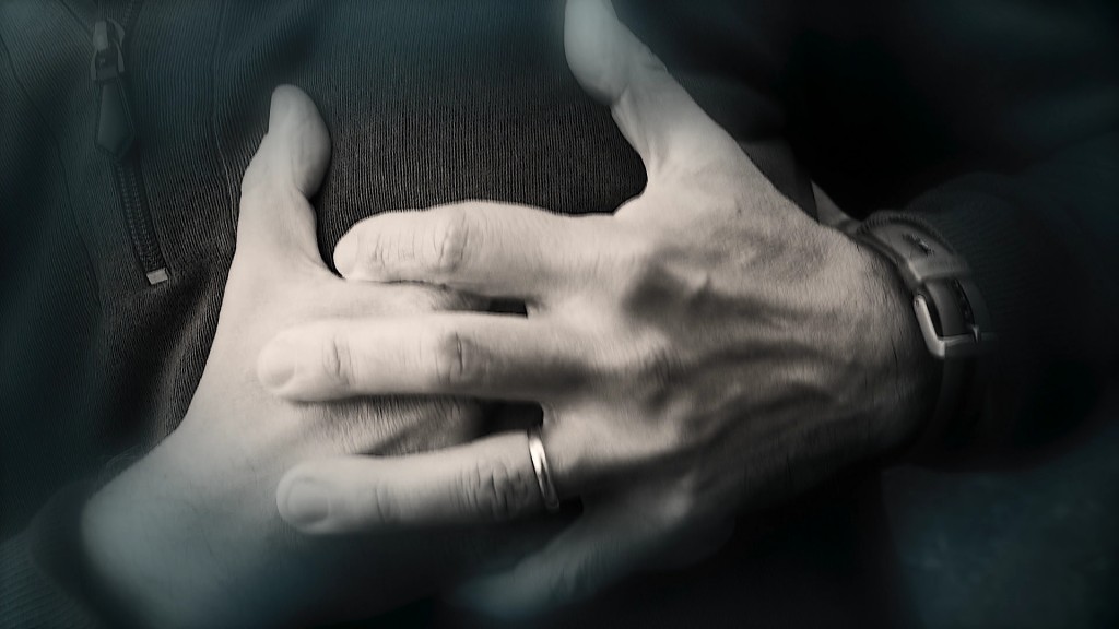 Foto: Ein Mann greift sich mit beiden Händen an die Brust