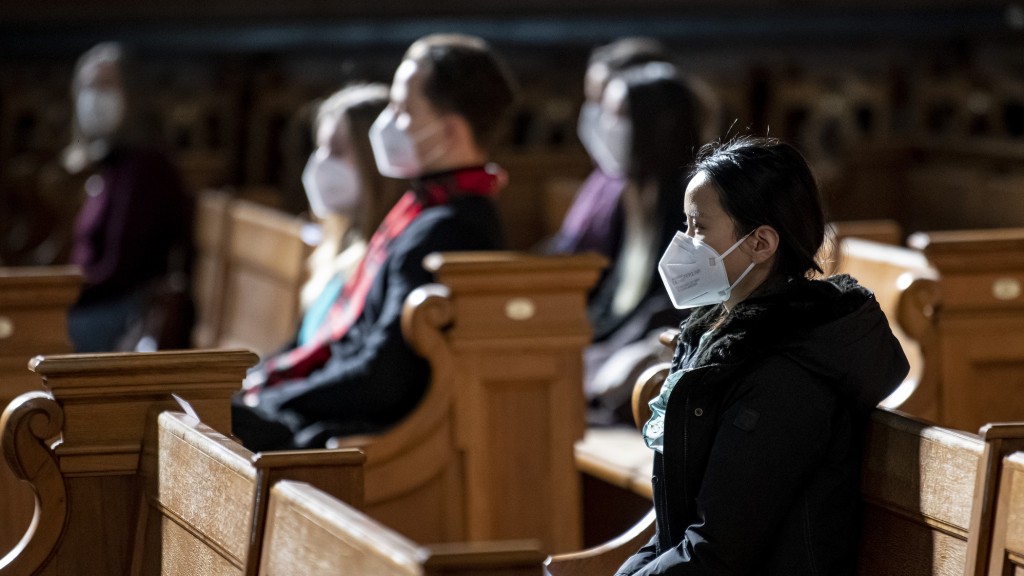 Gottesdienstbesucherinnen und -besucher mit Maske (Foto: picture alliance/dpa | Fabian Sommer)