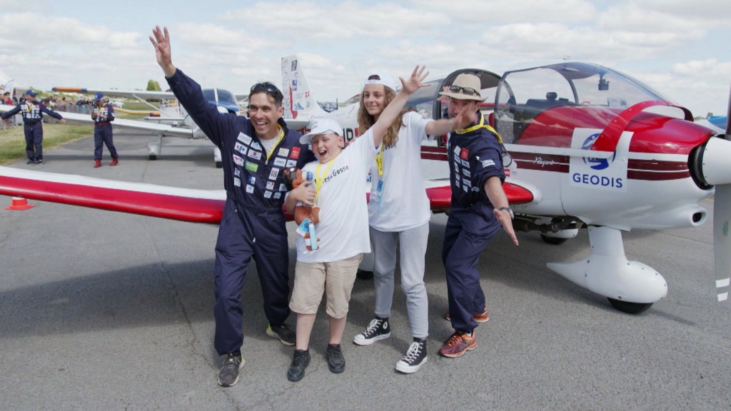 Foto: Die Piloten Aurélien Gosse und Ludger Rankers posieren mit zwei Kindern vor einem Flugzeug