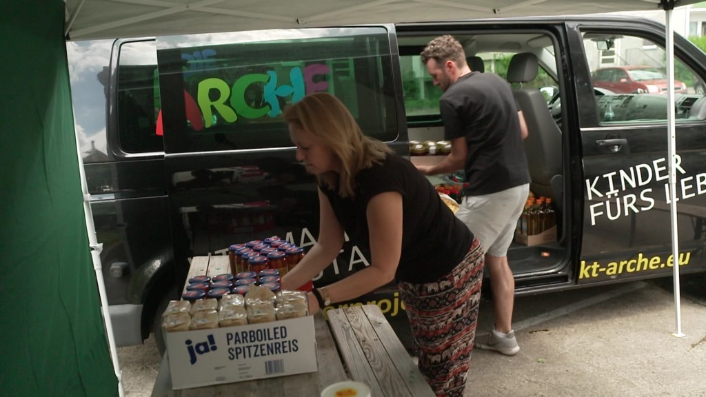 Foto: Eine Frau und ein Mann entladen einen Wagen der Arche mit Lebensmitteln