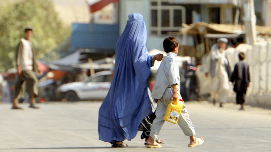 Straßenszene nahe Kundus: eine afghanische Burka-Trägerin mit Kind