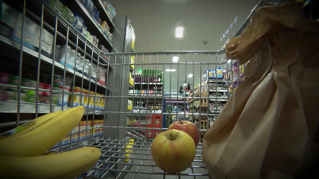 Blick auf Supermarktregal aus einem wenig gefüllten Einkaufswagen heraus