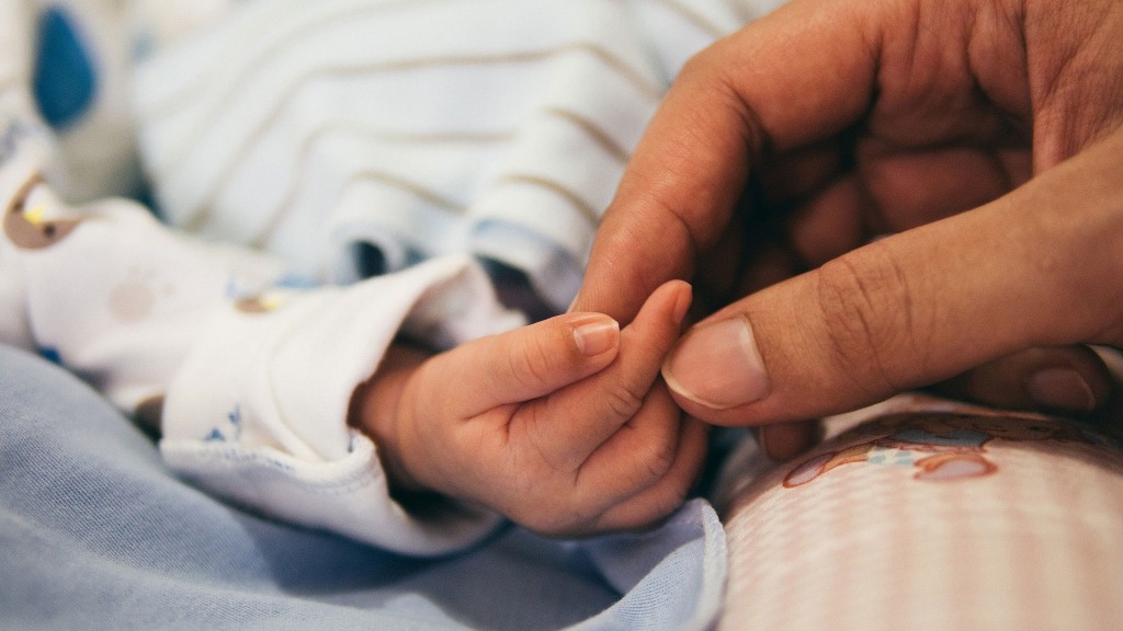Eine Person greift die rechte Hand eines Babys