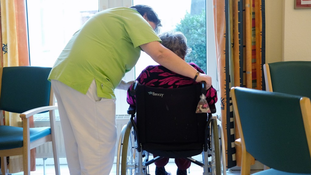 Eine Pflegerin spricht mit der Bewohnerin eines Pflegeheimes. 