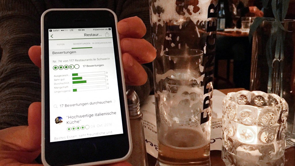 Auf einem Smartphone ist in einem Restaurant eine Bewertung-App zu sehen