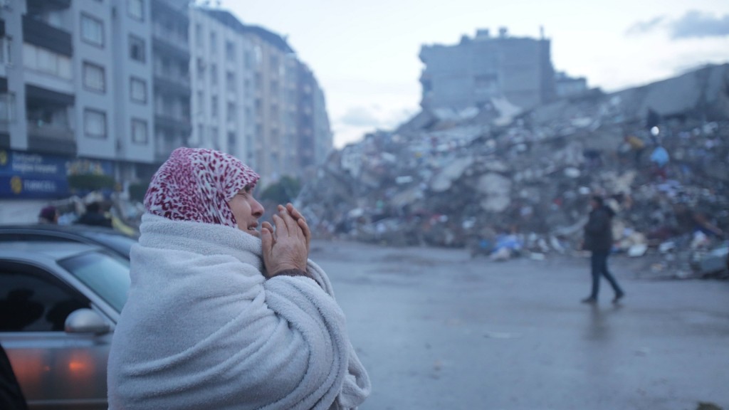 Erdbeben in der Türkei und Syrien, weinende Frau vor Trümmern
