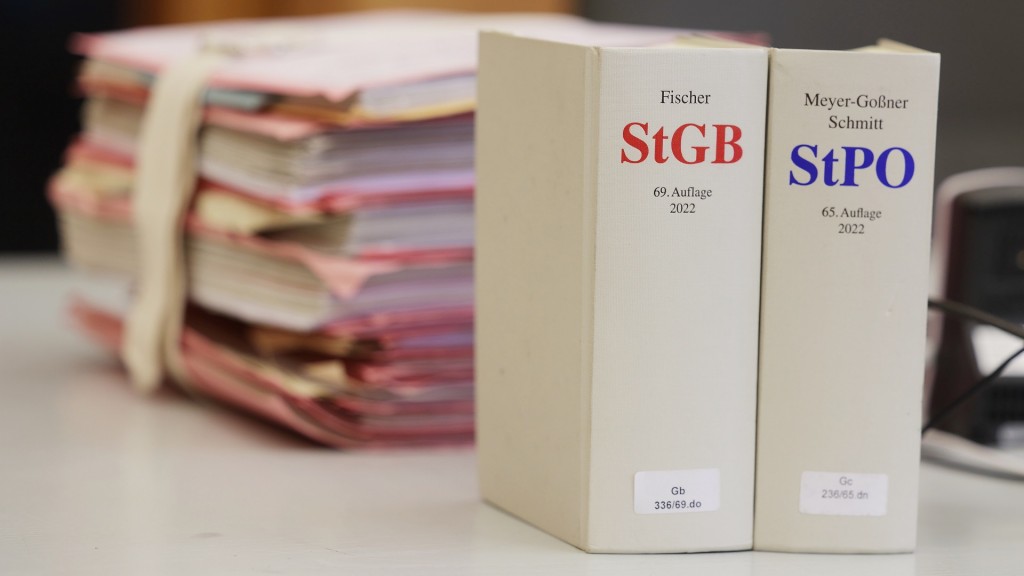 Gerichtsakten und Bücher zu Strafgesetzbuch und Strafprozessordnung liegen bzw. stehen liegen auf einem Tisch.