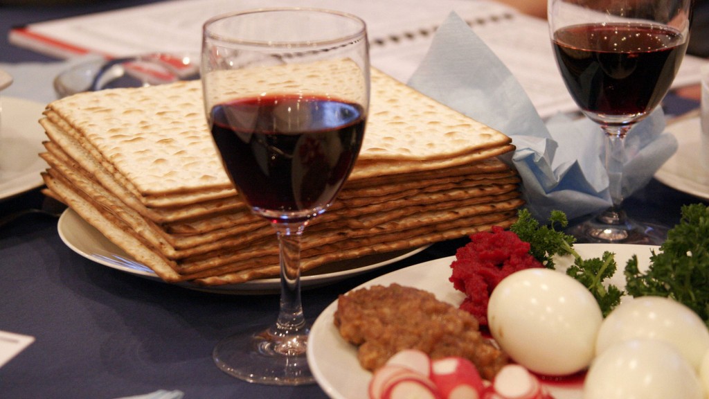 Tisch zum Pessachfest mit Mazza-Brot, Rotwein sowie ein Teller mit Petersilie, Eier, Radieschen und gebratenem Lammfleisch