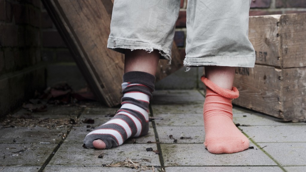 Kind mit unterschiedlichen und kaputten Socken