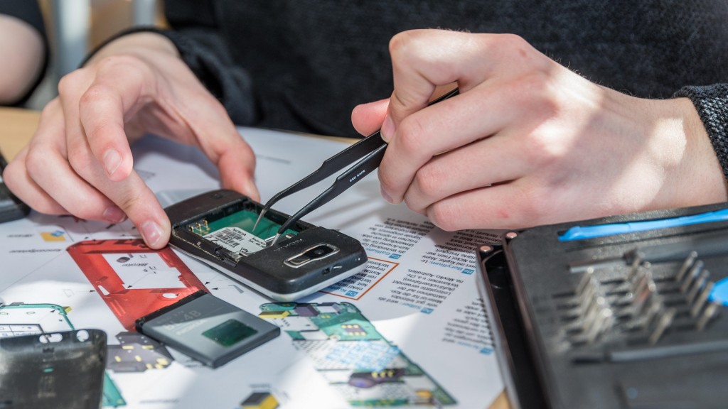 Foto: Recycling und Rohstoffgewinnung. Techniker zerlegt altes Handy.