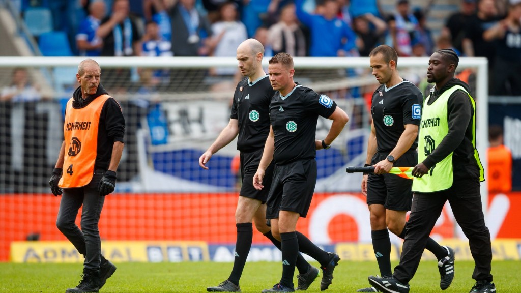 Das Schiedsrichter-Team um Robert Kampka verlässt unter Schutz das Spielfeld nach der Partie SV Elversberg gegen Hansa Rostock