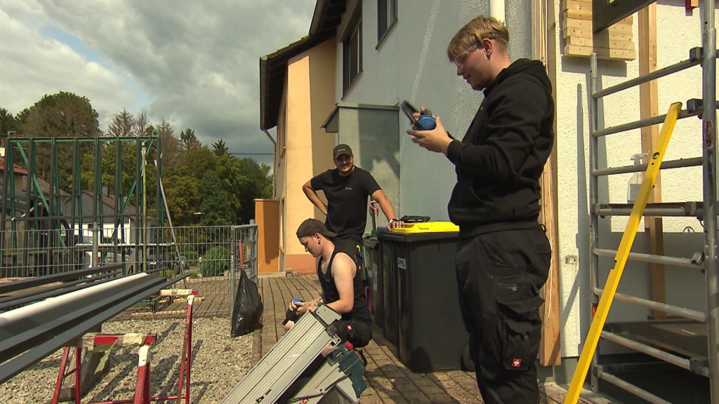 Foto: Drei Männer arbeiten an einer Terrasse