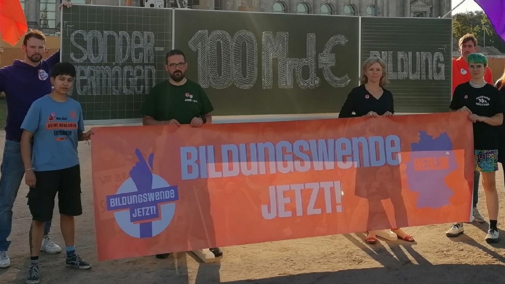 Bildungsprotest 2023. Lehrer und Schüler stehen mit einem Transparent 