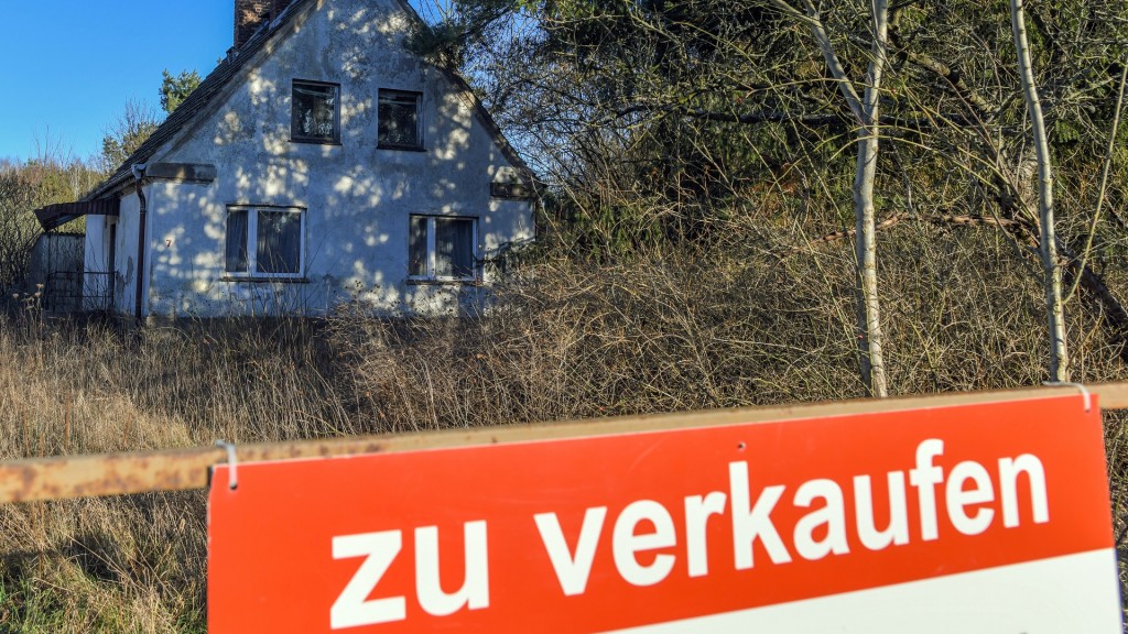 Ein Schild mit der Aufschrift «zu verkaufen» steht auf einem Grundstück mit einem Einfamilienhaus.