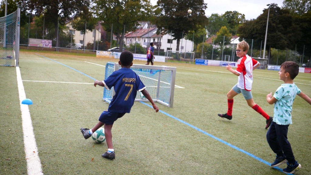Foto: Kinder spielen Fußball auf dem Sportplatz