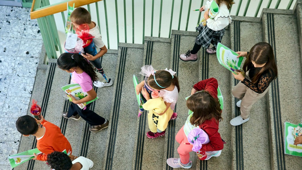 Kinder mit Schultüten laufen eine Treppe hinab