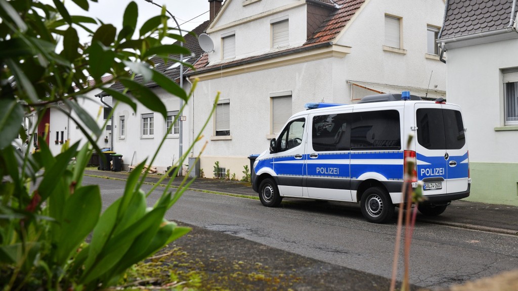 Foto: Ein Polizeifahrzeug steht vor einem Haus in Schiffweiler