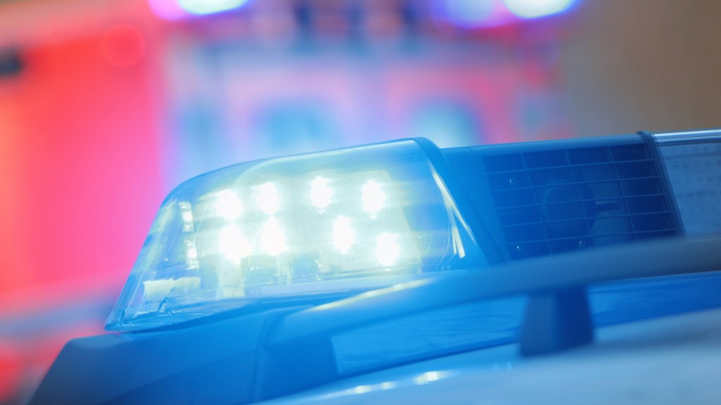 Symbolbild: Einsatzwagen der Polizei mit eingeschaltetem Blaulicht und Rettungswagen im Hintergrund
