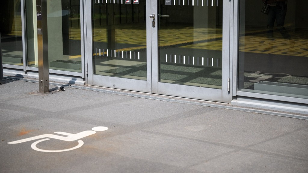 Foto: Ein Piktogramm außerhalb eines Gebäudes verweist auf einen behindertengerechten Eingang. 