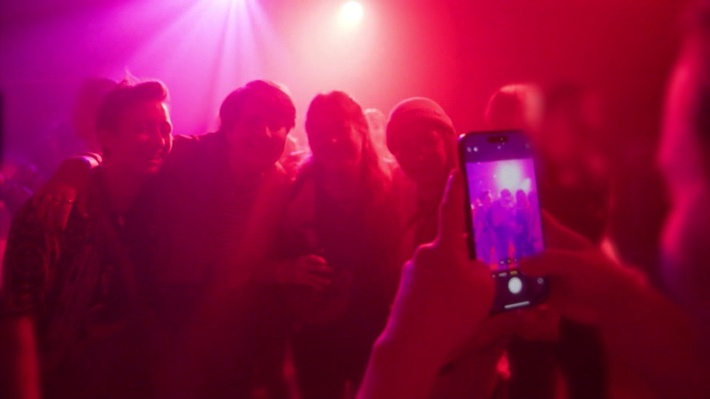Foto: Jemand macht in der Disco ein Bild von vier Jugendlichen