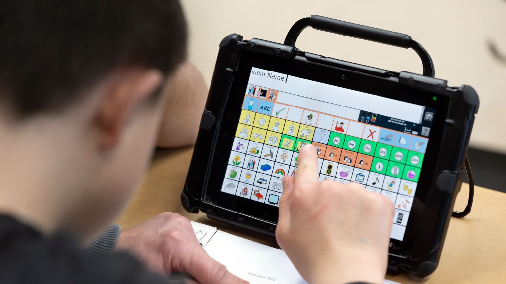 Ein Junge sitzt in einer Förderschule vor einem Tablet-PC