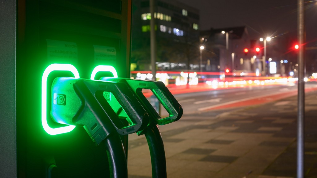 Foto: Grün leuchten Ladekabel an einer Schnellladesäule für Elektroautos.