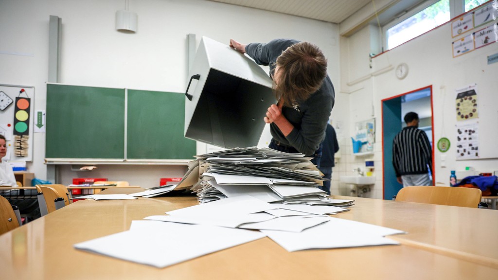 Foto. Stimmzettel aus der Wahlurne werden auf einem Tisch zum auszählen vorbereitet