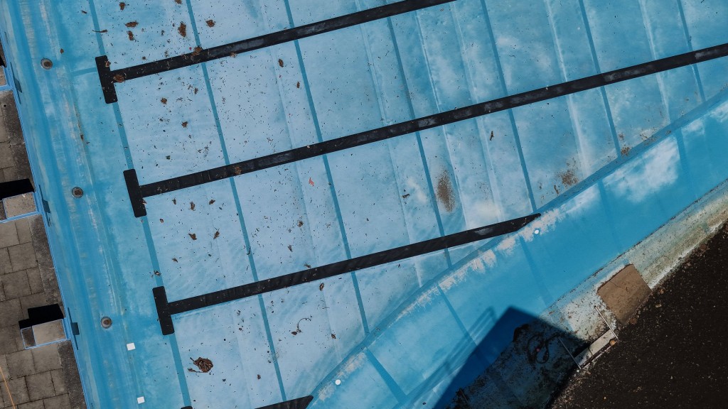 Foto: Das Schwimmbecken eines maroden Freibades ist leer, auf dem boden liegt Laub