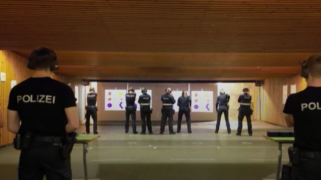 Foto: Polizisten stehen auf einem Schießstand vor einer Wand 