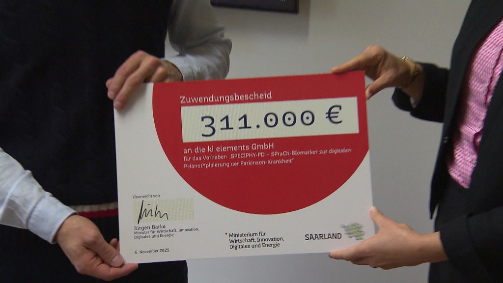 Foto: Ein Zuwendungsbescheid wird von vier Händen gehalten