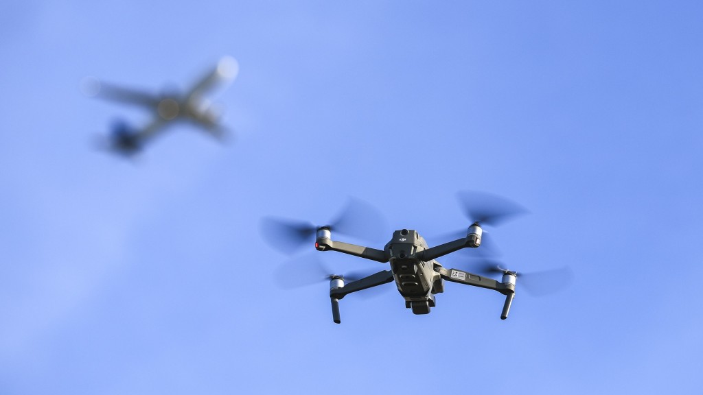 Eine Drohne fliegt am Himmel, im Hintergrund ist ein Flugzeug zu sehen.