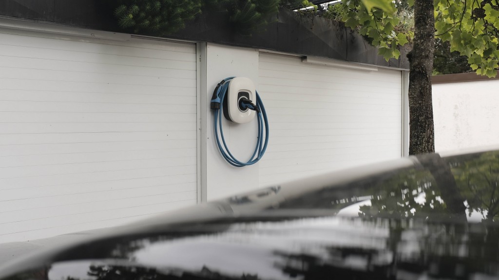 Wallbox Ladestation an Garage mit einem parkendem Auto davor 