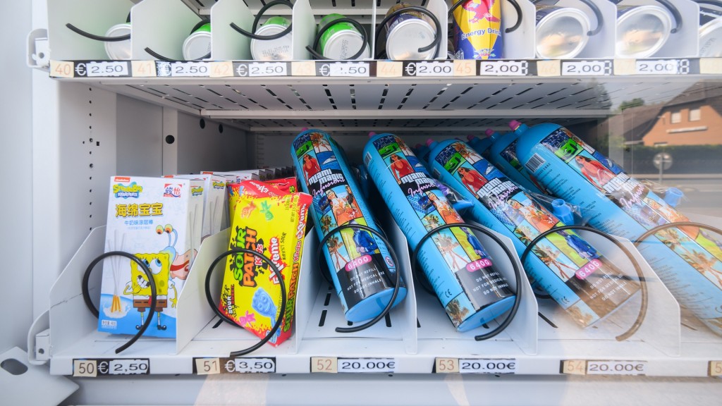 Ein Warenautomat, unter anderem mit Lachgasflaschen bestückt, steht vor einem Ladengeschäft. 