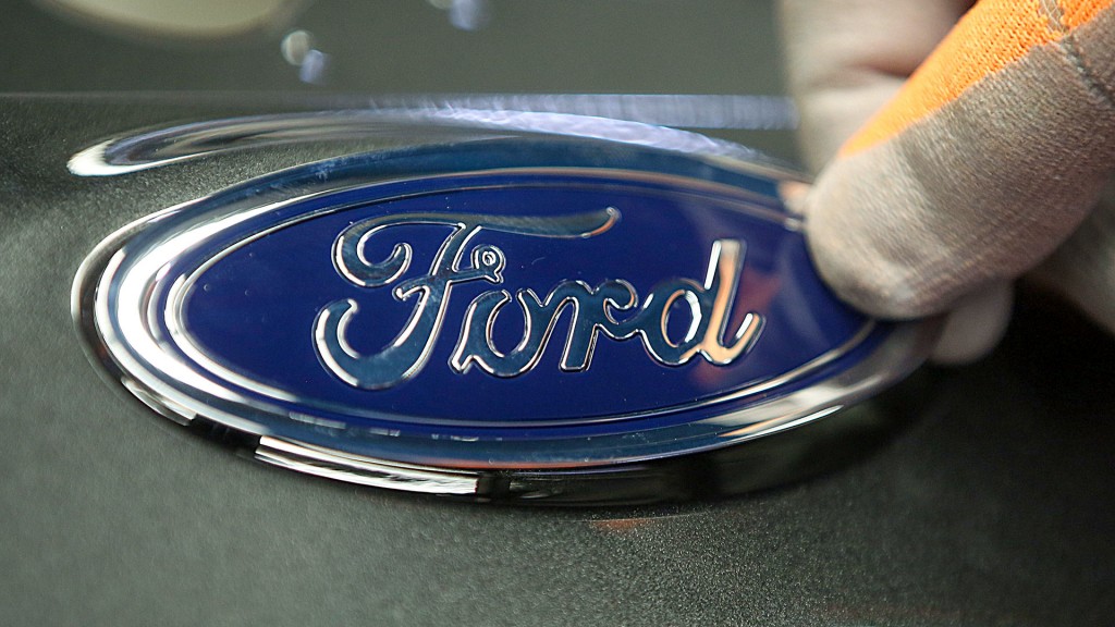 Foto: Eine Markenplakette von Ford wird an einem Fahrzeug angebracht