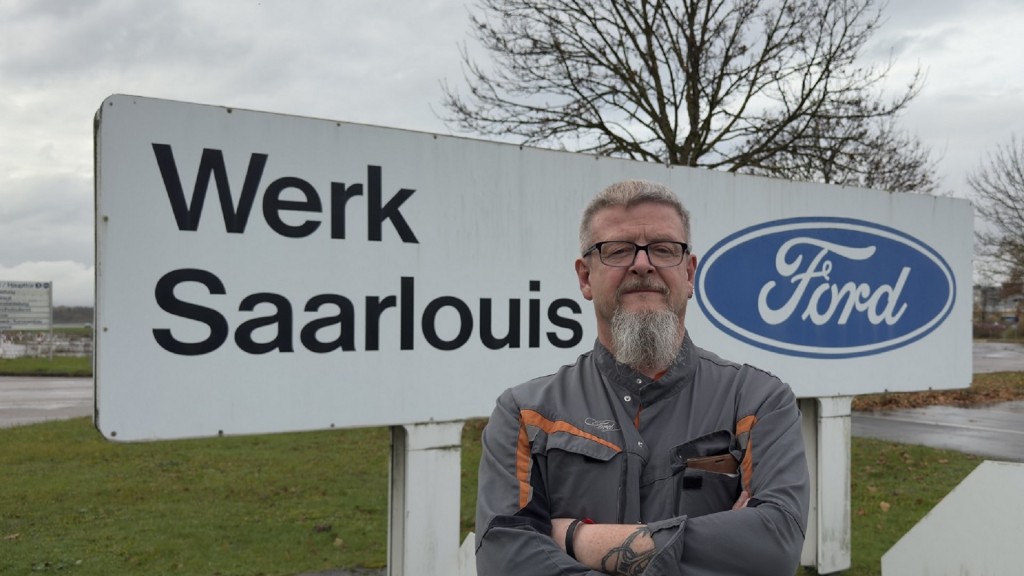 Foto: Mitarbeiter Michael Peters vor dem Schild Werk Saarlouis