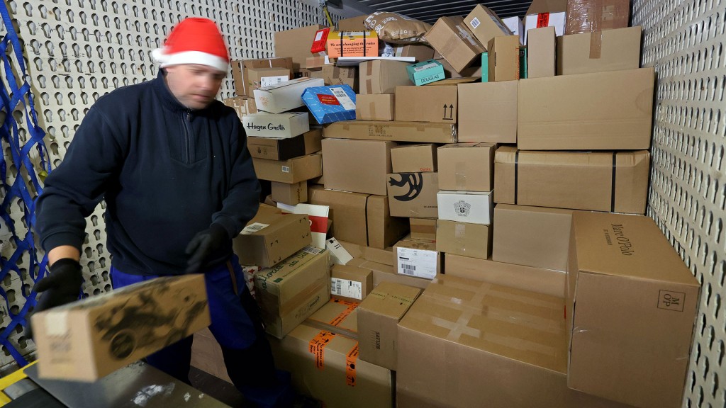 Paketzusteller mit Paketen und Nikolausmütze