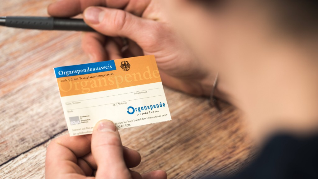 Ein Mann füllt einen Organspendeausweis aus.