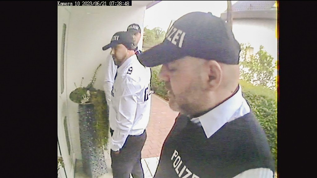 Falsche Polizisten vor einer Haustür, aus einer Videoaufnahmen von den Tätern 