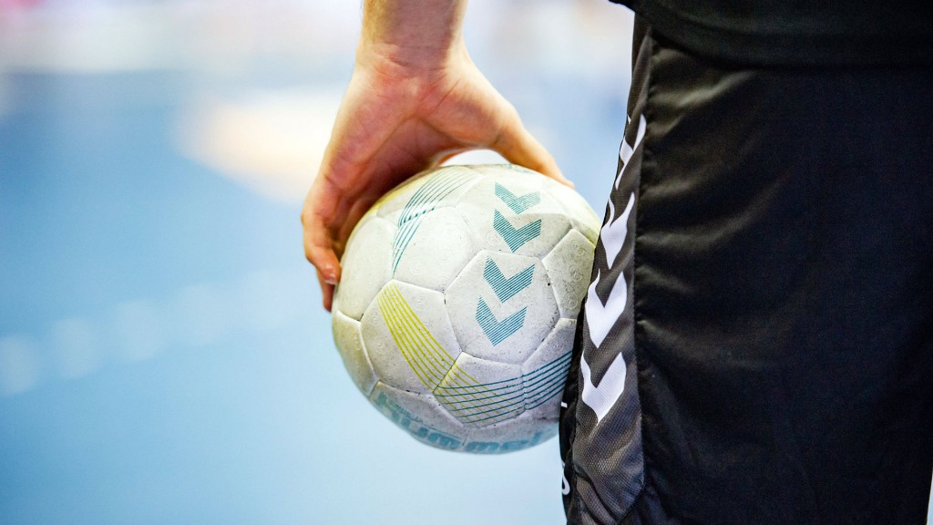 Foto: Ein Mann hält einen Handball auf dem Spielfeld
