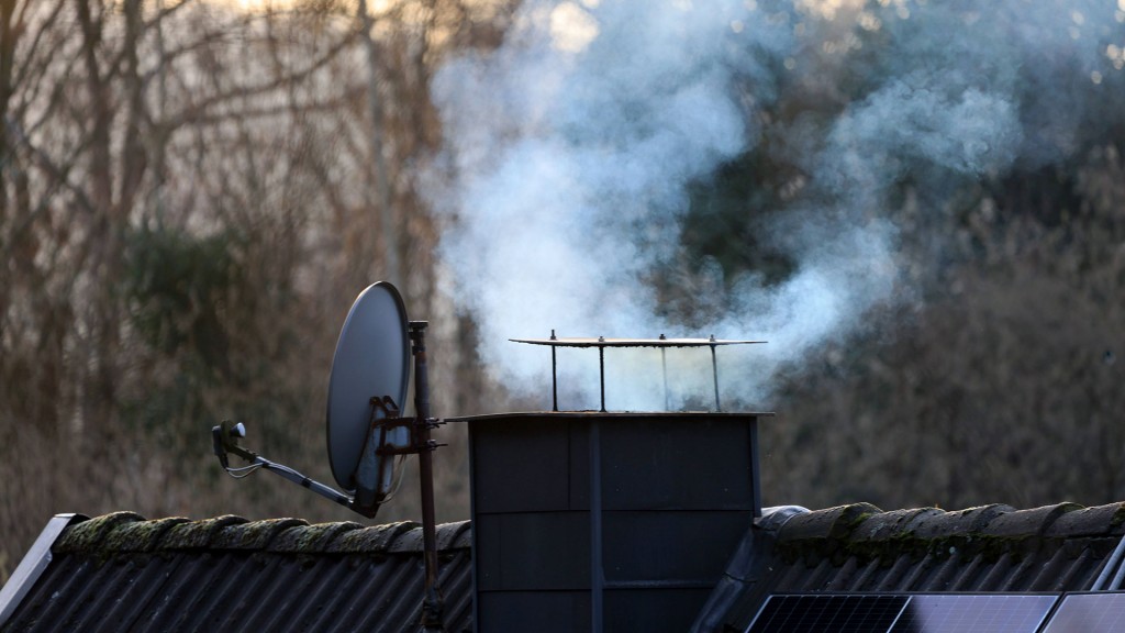 Ein qualmender Schornstein bei aufgehender Wintersonne