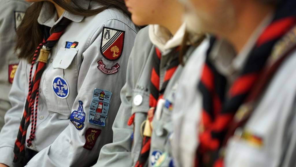 Pfadfinderinnen und Pfadfinder sitzen in ihren Uniformen zusammen