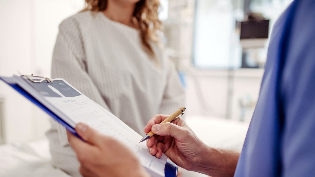 Medizinische Fachkraft notiert Daten und spricht mit einer Patientin.