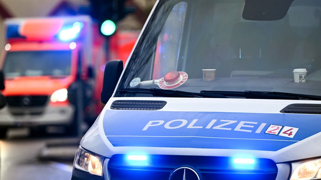 Polizeiabsperrung vor einem Einsatzwagen mit Blaulicht