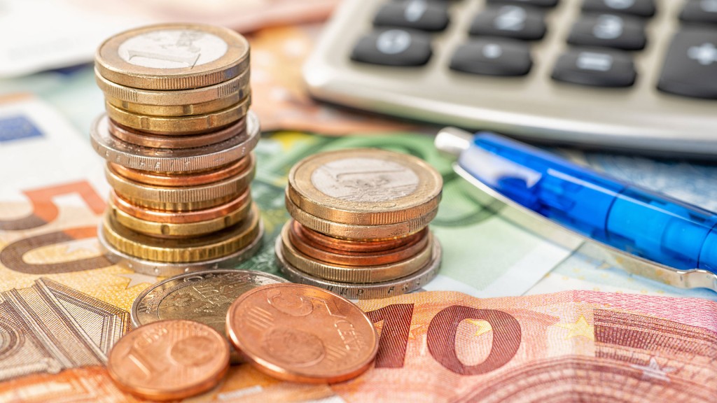 Euro Geldscheine und Münzen liegen auf einem Tisch, mit einer Taschenrechner und einem Stift