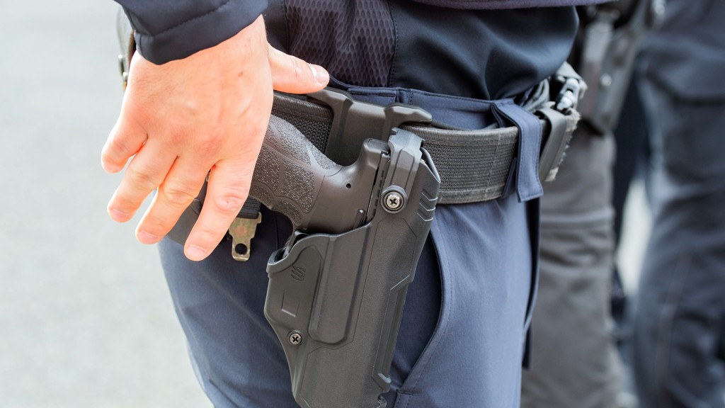 Ein Polizist greift nach seiner Dienstwaffe im Gürtelholster