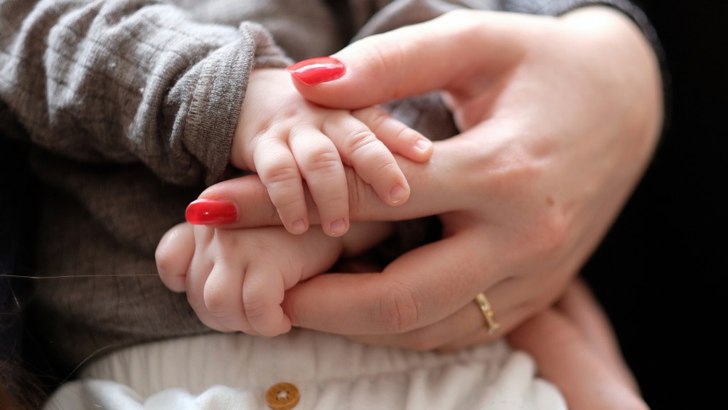 Hände einer Frau und eines Neugeborenen