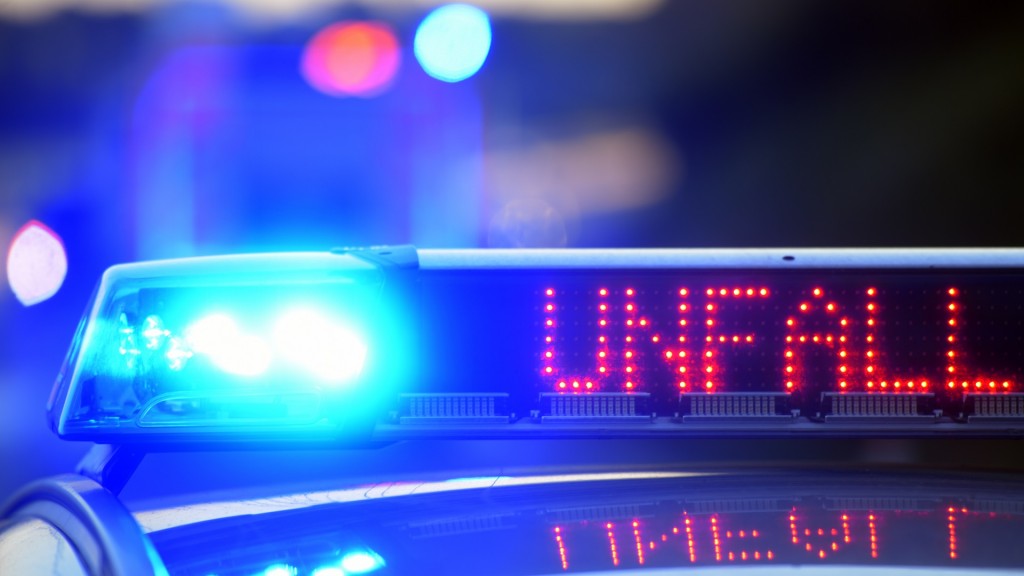 Auf einem Polizeifahrzeug warnt eine Leuchtschrift vor einer Unfallstelle.