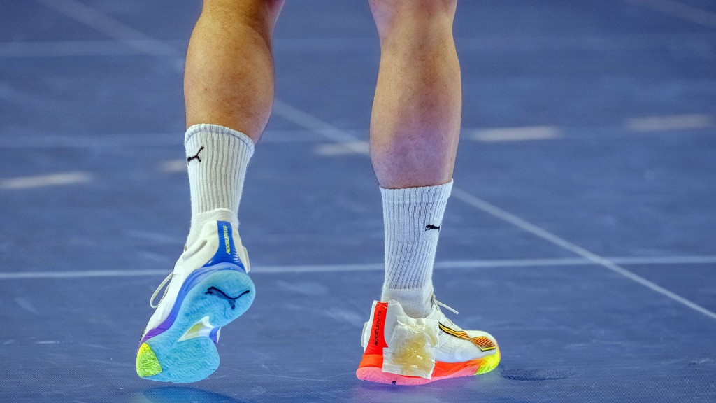 Foto: Ein Sportler steht auf einem modernen LED-Glasboben einer Sporthalle
