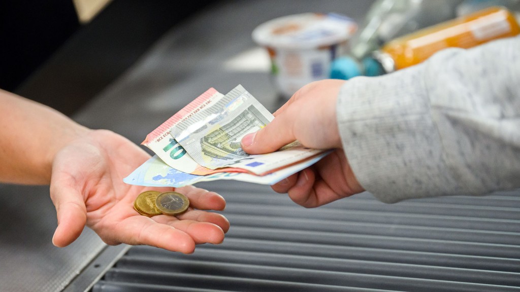Foto: Eine Kassiererin gibt einer Kundin Wechselgeld an der Kasse eines Supermarktes