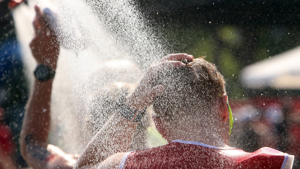 Athlet kühlt sich bei drückender Hitze unter einer Dusche mit kaltem Wasser ab.